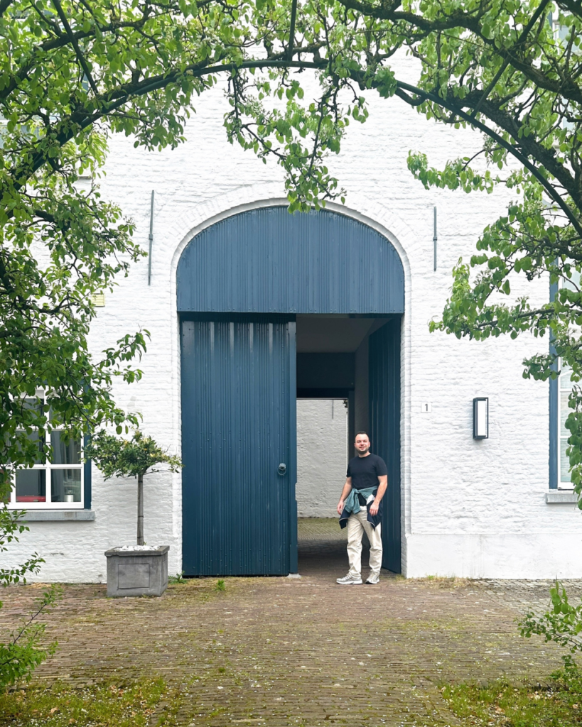 Dit zijn de mooiste hofjes van Den Bosch (ken jij ze allemaal al?) 4 Man wandelt de poort uit bij het Hof van Zevenenbergen in de historische binnenstad van Den Bosch