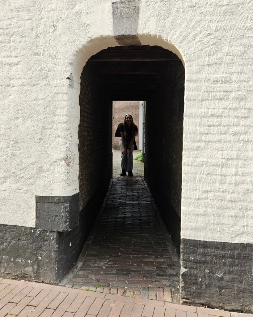 Dit zijn de mooiste hofjes van Den Bosch (ken jij ze allemaal al?) 2 Silhouet van een vrouw in een smal steegje in de historische binnenstad van Den Bosch bij Klein Lombartje