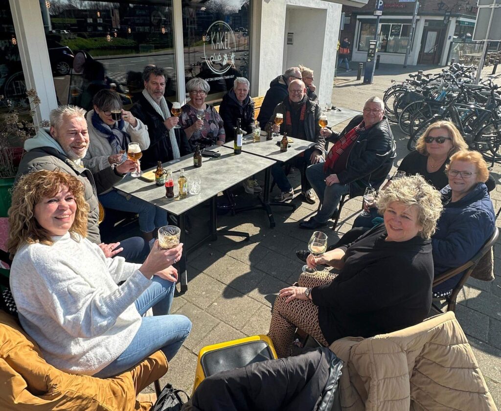 Groepsactiviteit in Den Bosch? 12 gezellige ideeën voor vrienden, familie of collega’s 3 Groep vrienden lacht samen op een zonnig terras in de historische binnenstad van Den Bosch