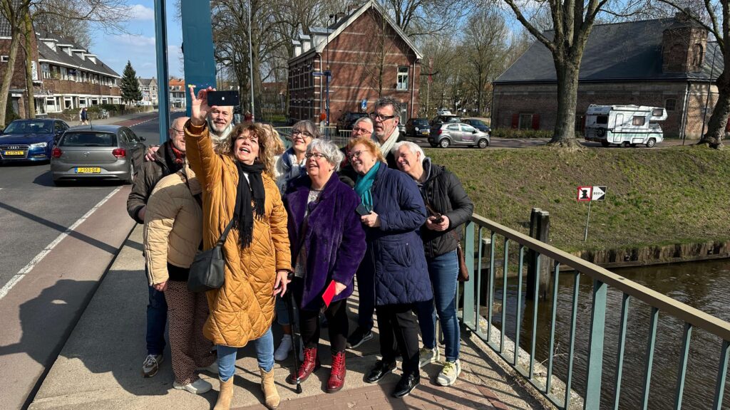 Vrolijke groep vrienden op leeftijd lacht samen in de historische binnenstad van Den Bosch